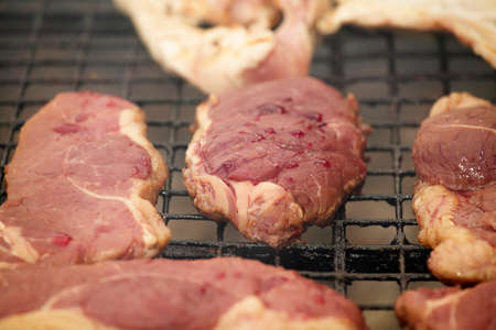 Beef steaks cooking on barbecue in close upの写真素材