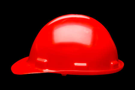 Red hard hat safety helmet isolated on black backgroundの写真素材