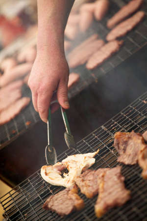 Chicken and beef steaks cooking on barbecueの写真素材