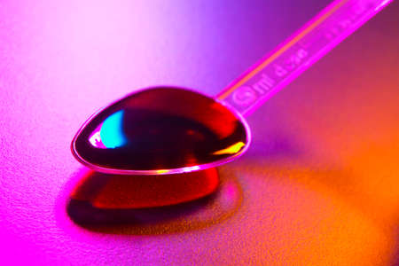 Plastic spoon containing dose of medicine in close upの写真素材
