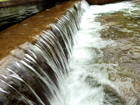 Small waterfall, artificial cascade on the river,