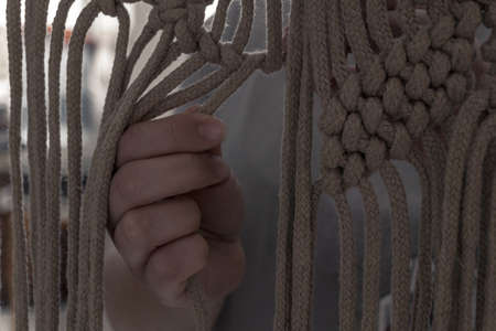 hands weaving knots for a beautiful macramÃ©