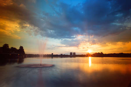 Sunset of the lake with fountainsの写真素材