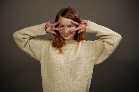 pretty young red haired girl in sweater isolatedの写真素材