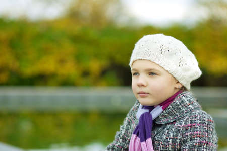 dreaming young blonde girl in white beret relaxing near river looking appearの写真素材