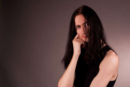 young handsome emo gothic man thinking isolated on grayの写真素材