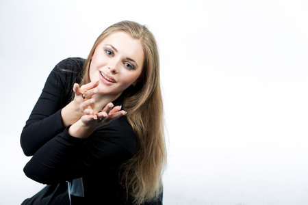 young pretty caucasian blond sitting with hands lifted in front sending kiss isolated over whiteの写真素材