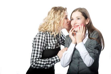two girlfriends sharing secrets with each other isolated の写真素材