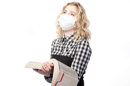 blond with encyclopedia in medical mask against viruses の写真素材