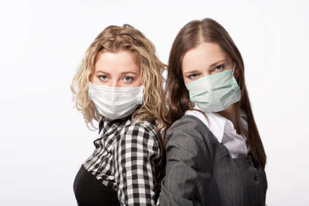 girls in medical masks standing together against virusesの写真素材