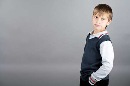 young caucasian teenager boy in sweater and strong willed look standing isolated over gray backgroundの写真素材