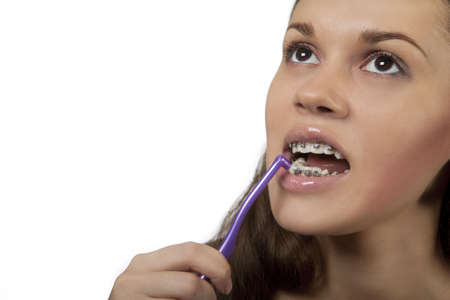 pretty nice dark hair girl cleaning teeth using diferent angles for round toothbrush isolated on...
