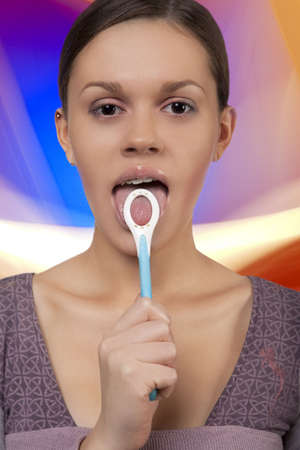 young dark hair girl standing holding round orthobrush near mouth open and smilingの写真素材