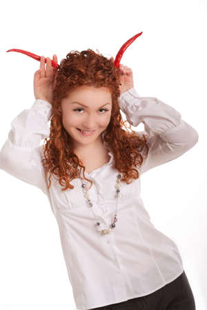 pretty and beautiful young red haired caucasian girl in nice shirt with long beads playing with two chilly pods making imaginative pods and having fun isolated on whiteの写真素材