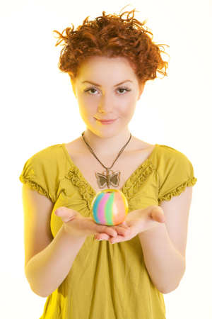 red haired caucasian girl standing symmetrically and holding colored apple on palms and smiling with sincere smile isolated on pure white backgroundの写真素材