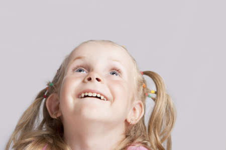 smiling little blond girl making her head llifted with laughing positive expression isolated