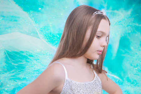 small little caucasian blond girl wearing crown standing over artistic backgroundの写真素材