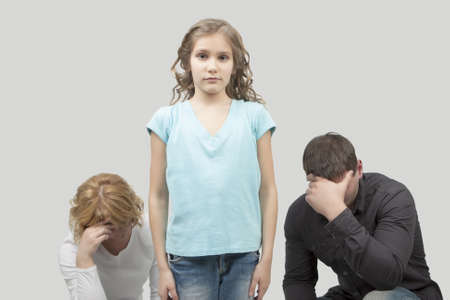 father and mother misunderstand their teenage girl standing separated from each other needed support and dialog isolated over white backgroundの写真素材