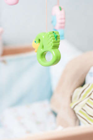 child cradle with toys hanging around, shot  with a very shallow depth of fieldの写真素材
