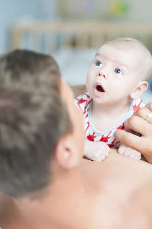 young caucasian handsome masculine father and his little newborn son communicating together