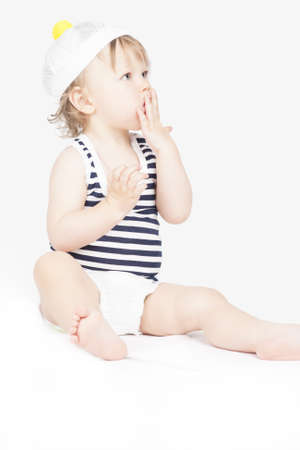 portrait of small little girl sitting and lookign up over white backgroundの写真素材
