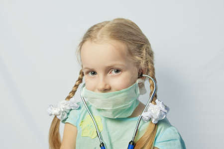little caucasian blond girl wearing medical mask over bright background