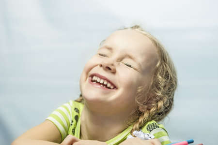 portrait of happy little blond girl with colorful pencils