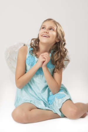 lovely portrait of cute little girl wearing angels wings and smilingの写真素材