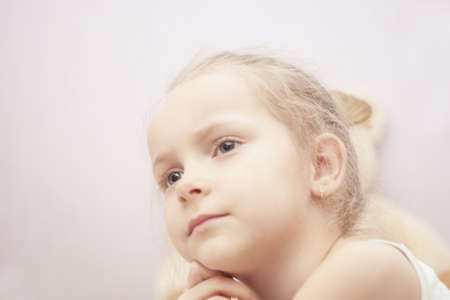 close up portrait of blond little girl thinking shoot indoorsの写真素材