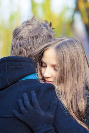 young caucasian female girl hugs her male handsome man standing outsideの写真素材