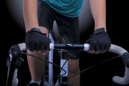 closeup of hands and handlebars of a professional biking female athlete shot in studio  isolated over black  horizontal shotの写真素材