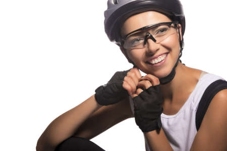 portrait of professional female bike athlete sitting and fixing her protective helmet.isolated over pure white background. horizontal imageの写真素材