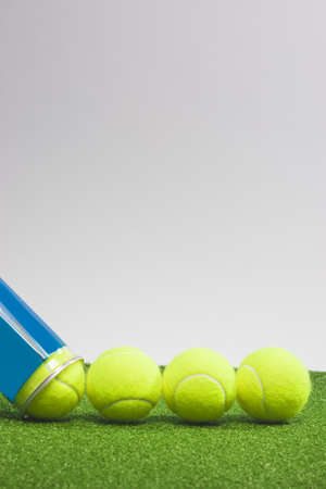 Tennis concepts: four tennis balls close to a container lie on green grass surface. vertical  imageの写真素材