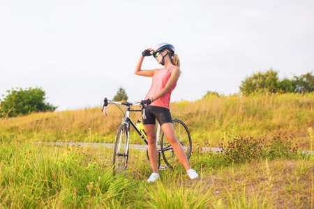 portrait of a young female sport athlete with racing bike resting outsie  horizontal imageの写真素材