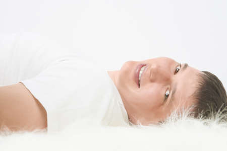 Portrait of happy Caucasian handsome man lying on floor and smiling. Horizontal imageの写真素材