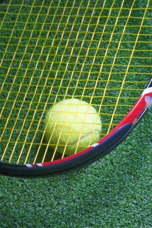 Tennis Racquet with Ball over Green Artificial Grass. Vertical Imageの写真素材