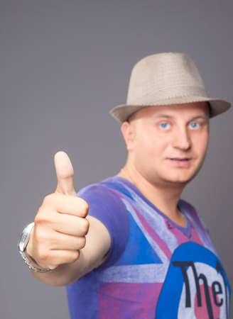 Portrait of Young Man Showing Thumbs up isolated over Gray. Vertical Image