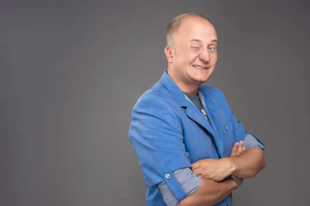 Portrait of Young Man Winking Standing Isolated over Grayの写真素材