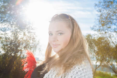 Portrait of Young Thoughtful Woman Outside Standing Against Sunlight and Smiling. Horizontal Imageの写真素材