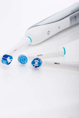 Modern Electric Toothbrush with a Few Spare Heads Together Over white. Vertical Imageの写真素材