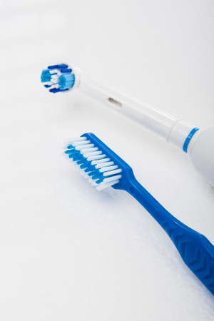 Traditional Manual and Electric Toothbrush Together Over White. Vertical Imageの写真素材