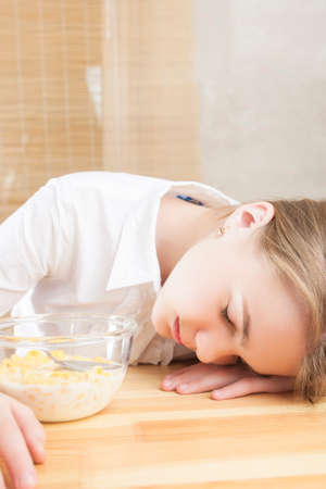 Portrait of Teenager Girl Sleeping on Table Surface after Cereal Breakfast. Vertical Image