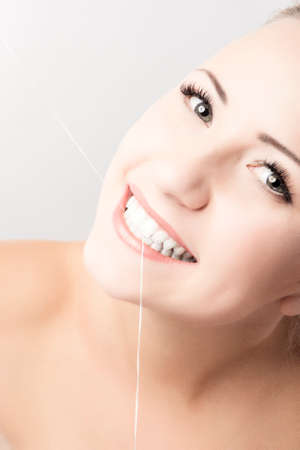 Portrait of Caucasian Woman Holding Dental Floss. Isolated Over White. Vertical Image