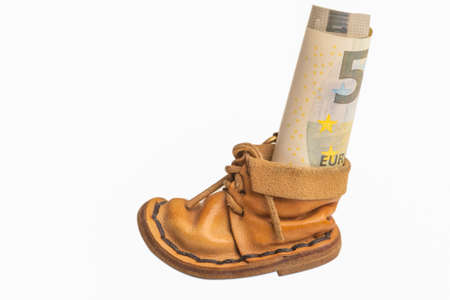 Money Roll in Symbolic Leather Shoe as Savings. Horizontal Image. Isolated On Whiteの写真素材