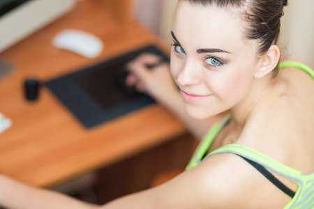 Smiling Happy Female Retoucher at Work Looking Backwards. Horizontal Image Composition