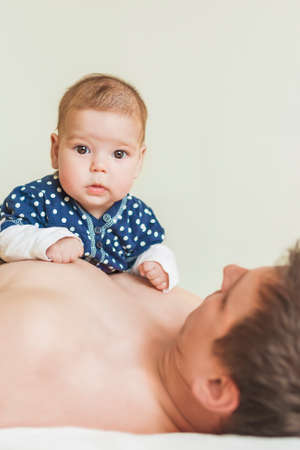 Portrait of Young Father and His Newborn Daughter. Vertical Image Composition
