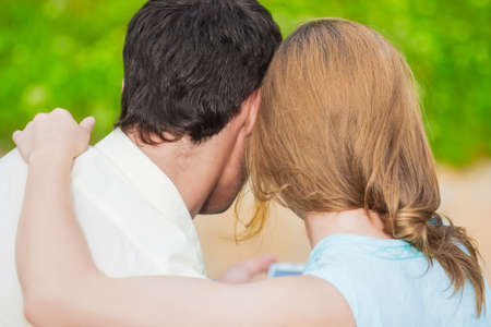 Back View of Two Young Lovers Together Outdoors Reading e-Book. Horizontal Image Compositionの写真素材