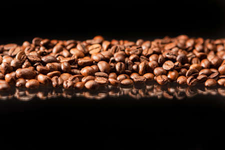 Line of Aromatic Roasted Coffee Beans Placed over Black Background.Horizontal Image Compositionの写真素材