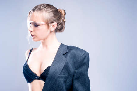 Fashion Concept: One Sexy and Sensual Caucasian Woman Dressed in Gray Suite Posing Against Gray Background.Horizontal Image Compositionの写真素材