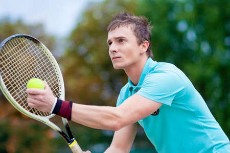 Sport and Tennis Concept: Handsome Caucasian Man With Tennis Raquet Preparing to Serve Ball On Court. Horizontal imageの写真素材
